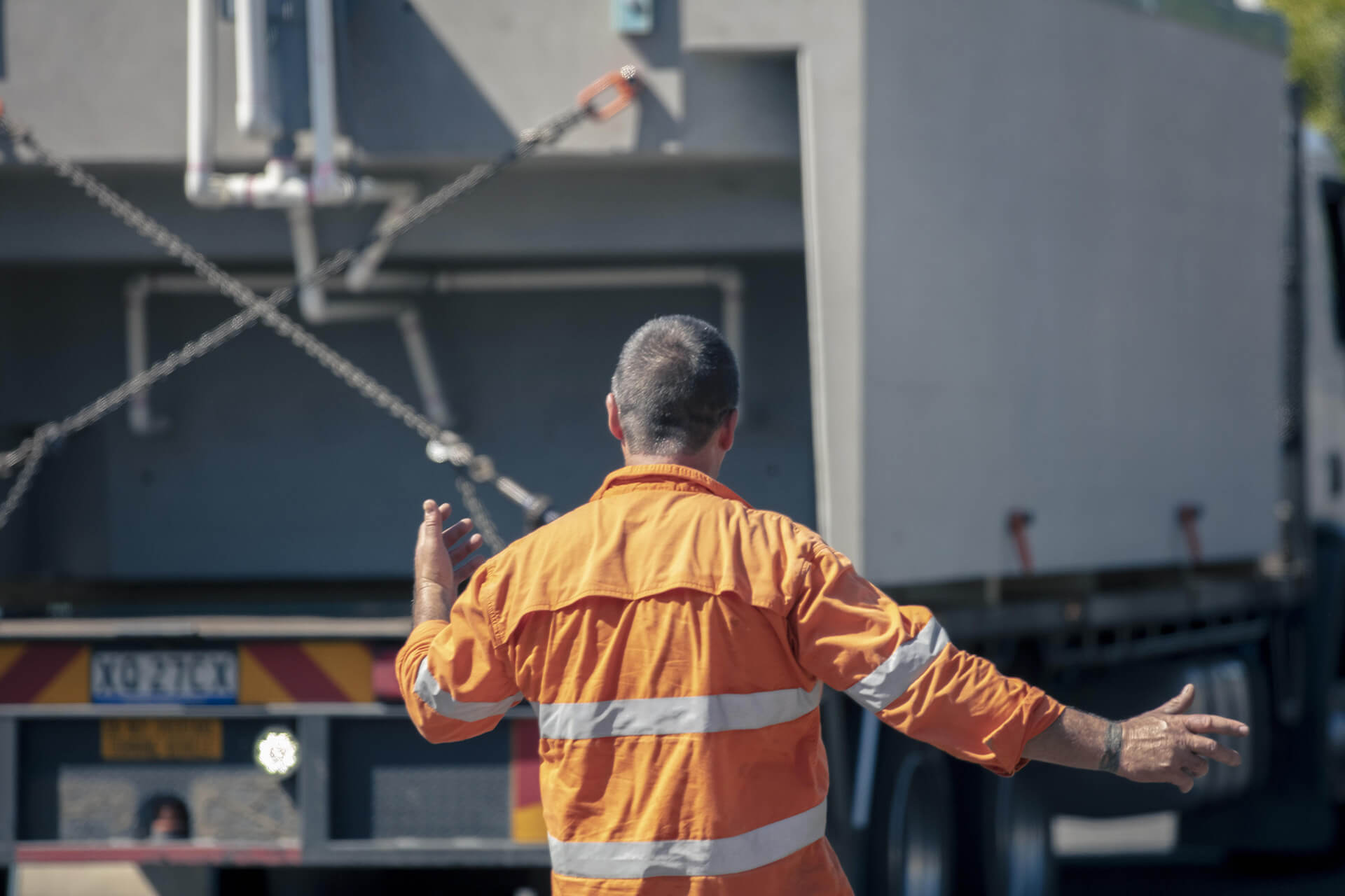 Constuction worker directs Plungie delivery truck on-site.